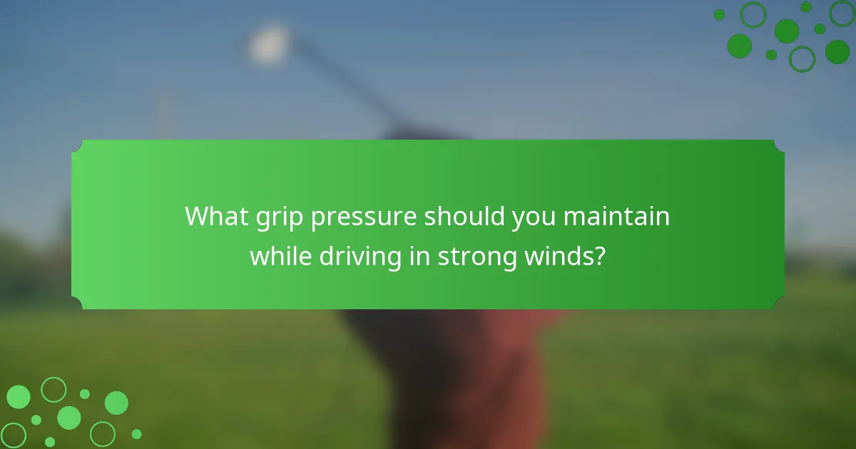 What grip pressure should you maintain while driving in strong winds?